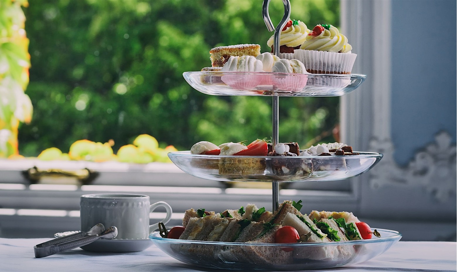 mothers day afternoon tea prosecco being poured into glass with cakes and sandwiches on stand