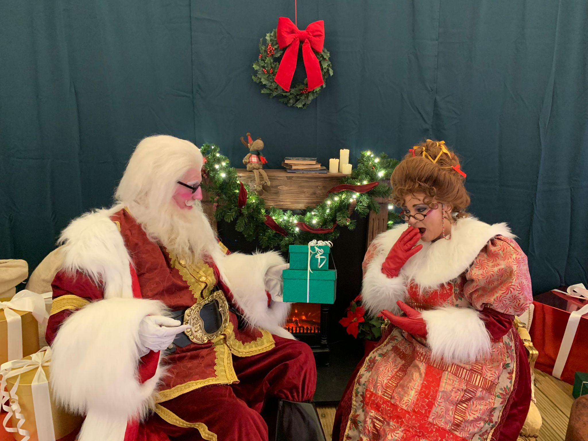 santa and mrs claus daytime festive grotto exchanging gifts 