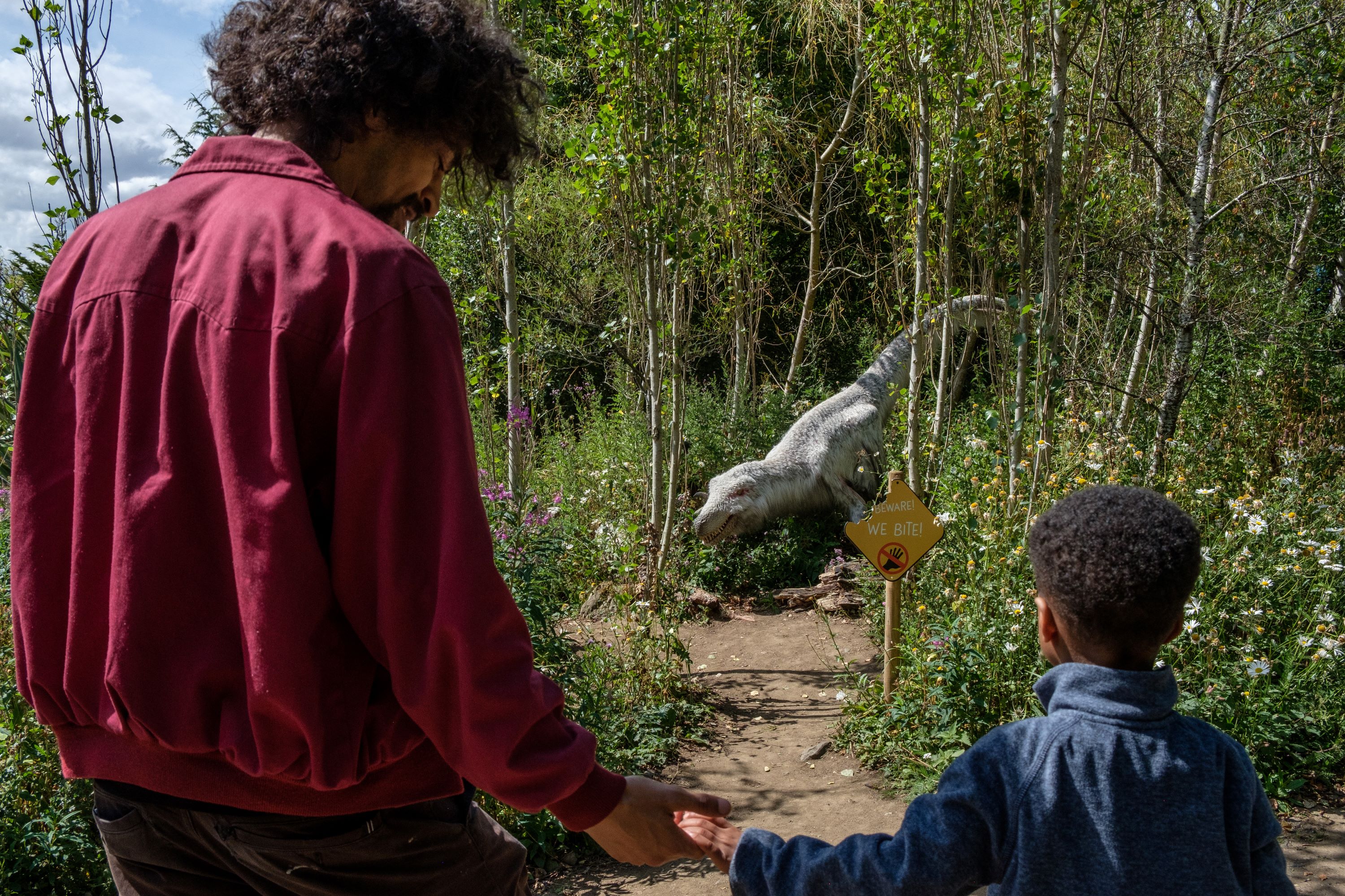 dad and child holding hands looking at dinosaur IMAGE: Robin Mair 2022