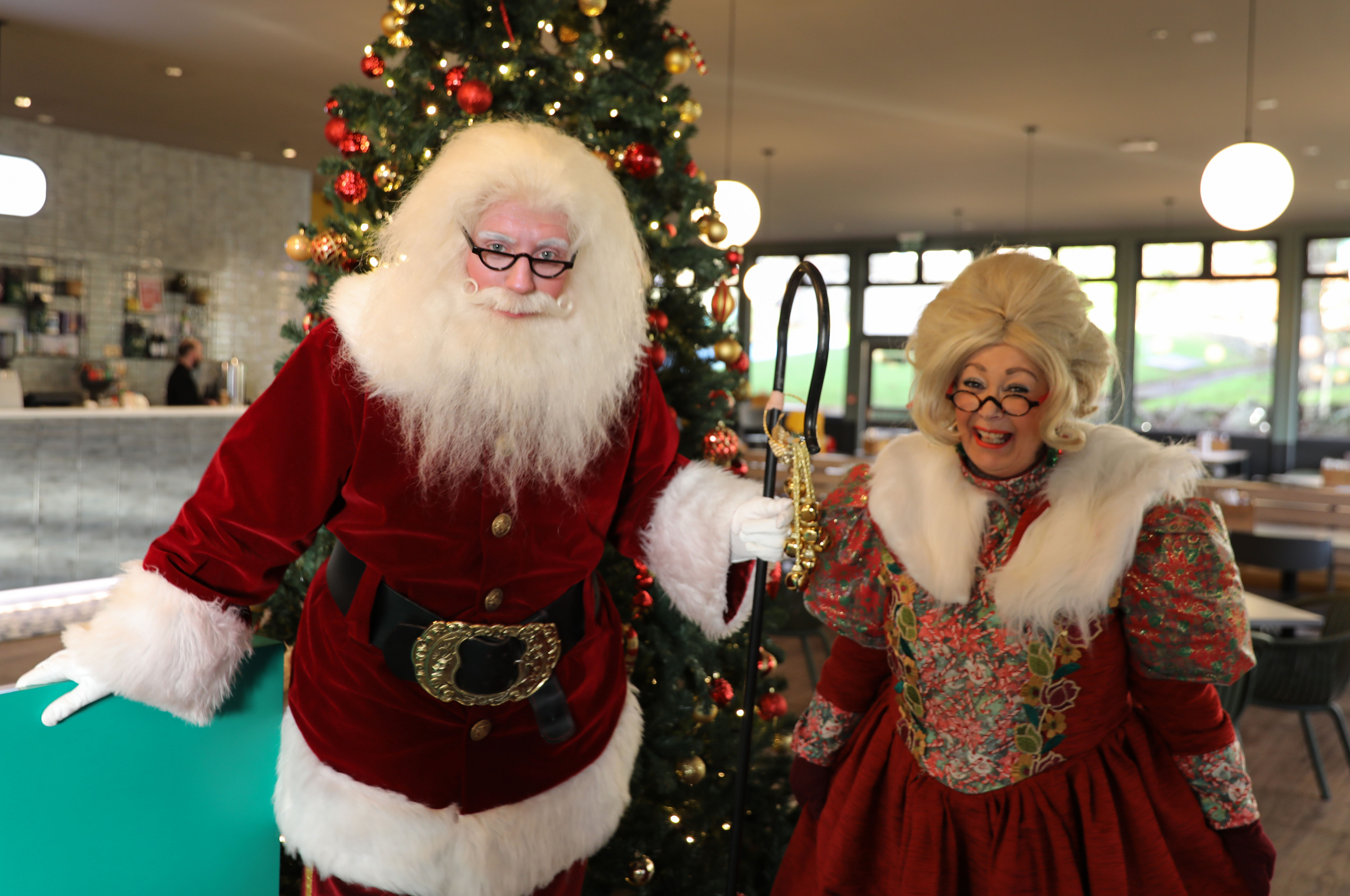 santa and mrs claus daytime festive grotto exchanging gifts 