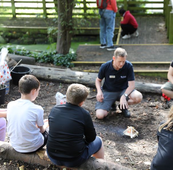 children in wildlife garden with member of education team