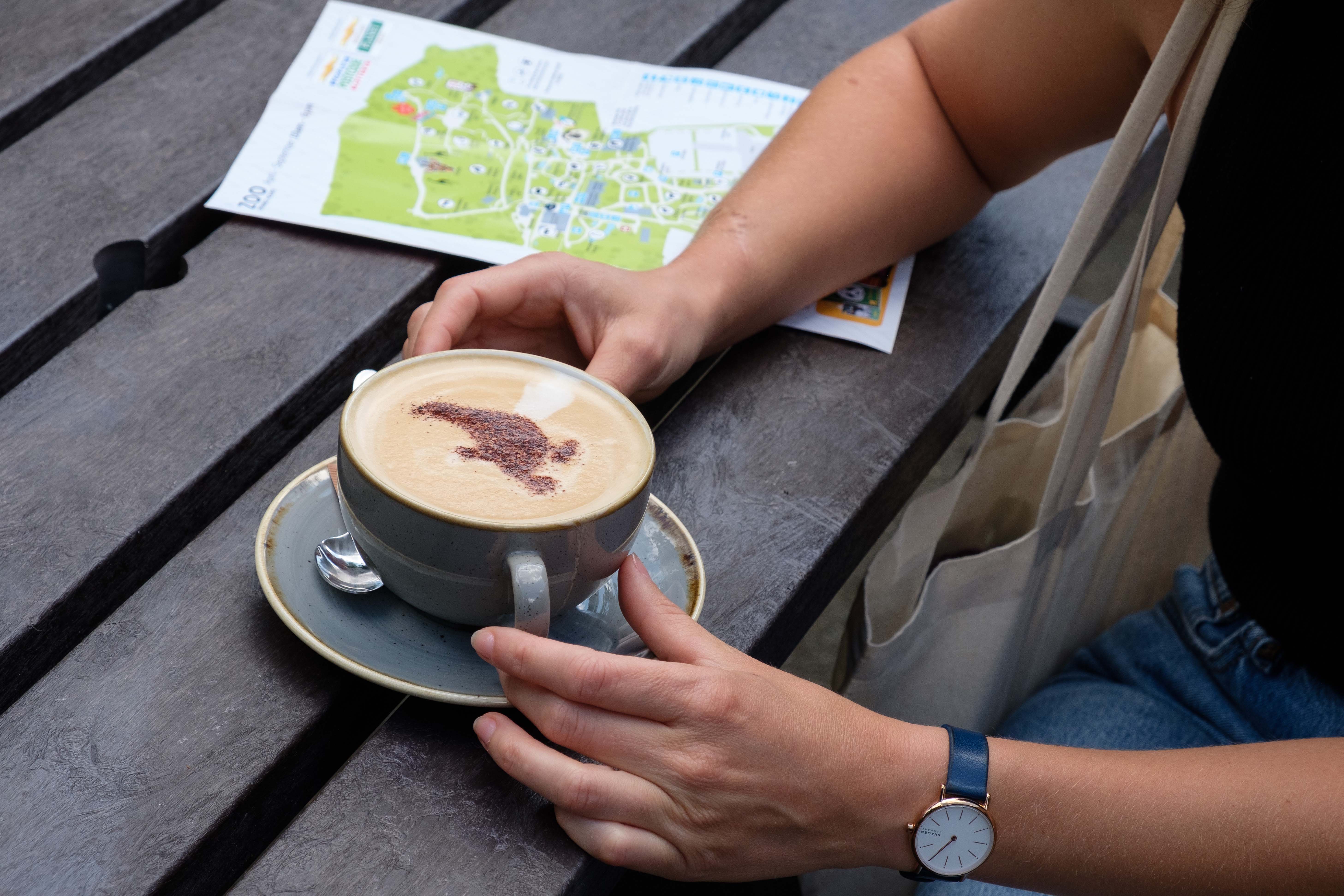 Hand holding coffee mug on bench IMAGE: Robin Mair 2022