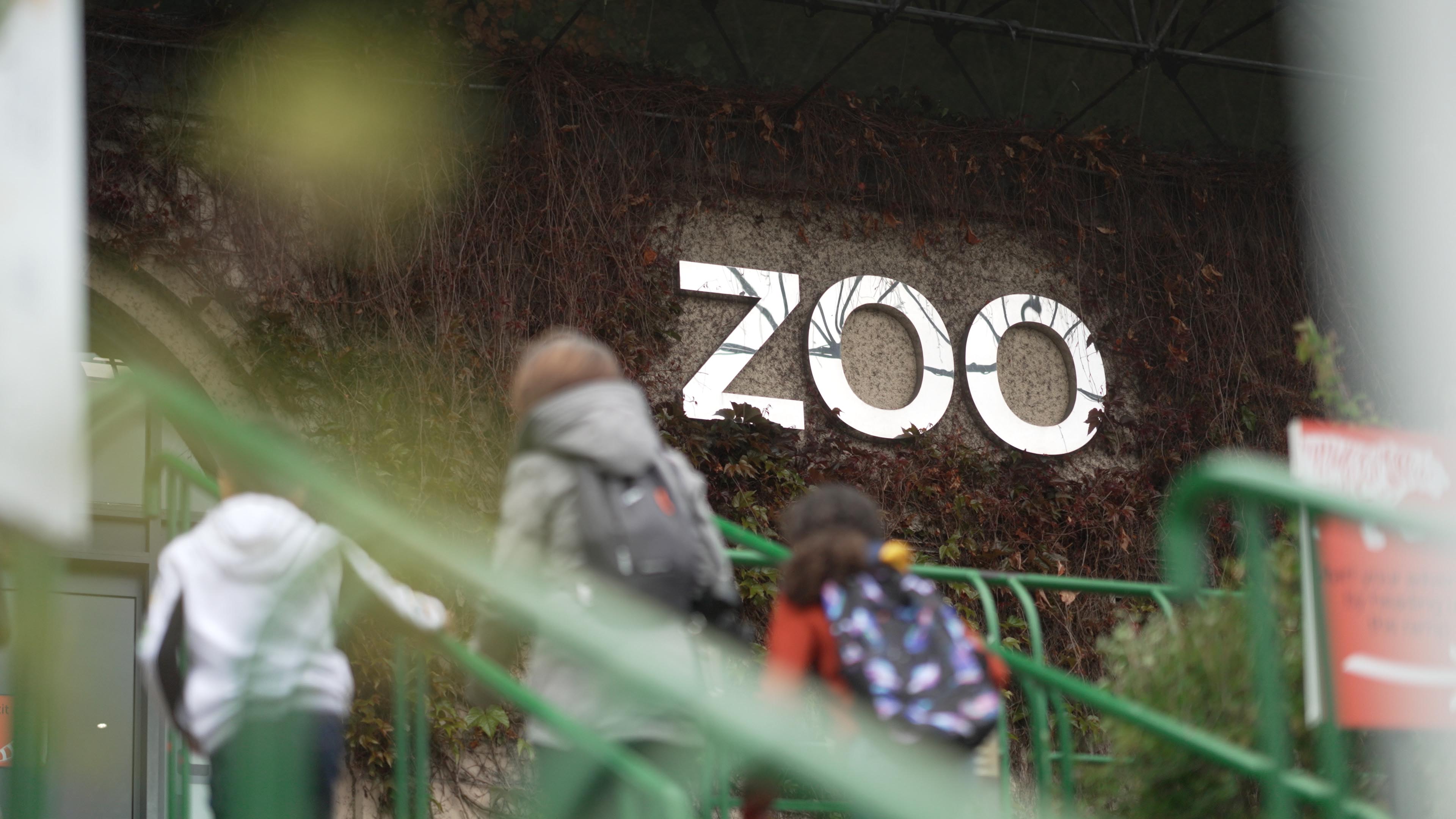 Edinburgh Zoo silver entrance sign with family in the foreground IMAGE: FoSho 2022
