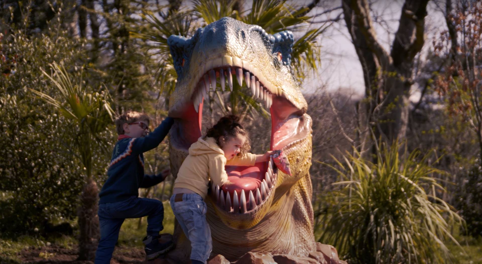 Boy and girl climbing on dinosaur at Dinosaurs! IMAGE: FoSho 2022