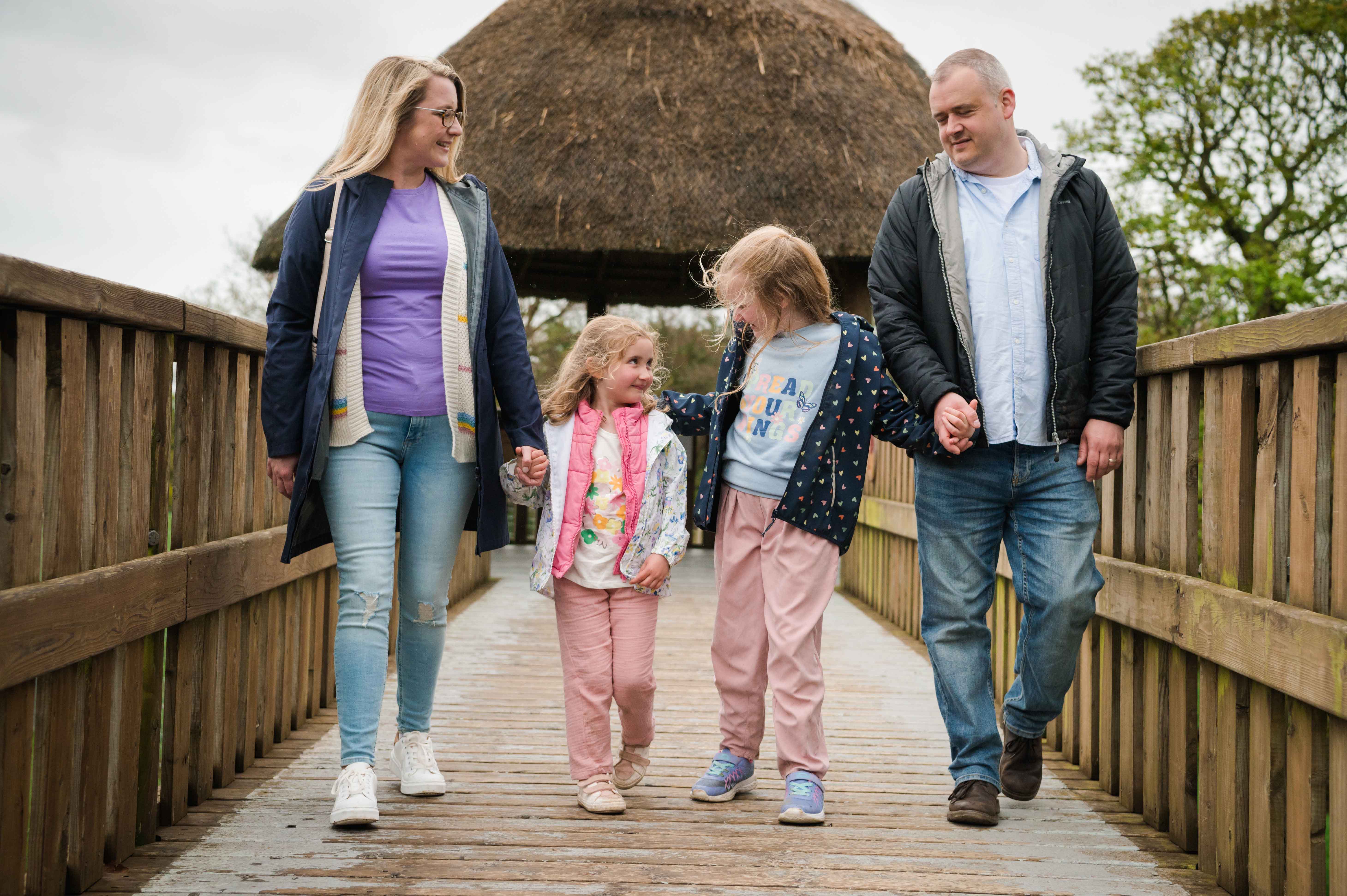 Family walking holding hands on giraffe walkway IMAGE: Rachel Hein 2023