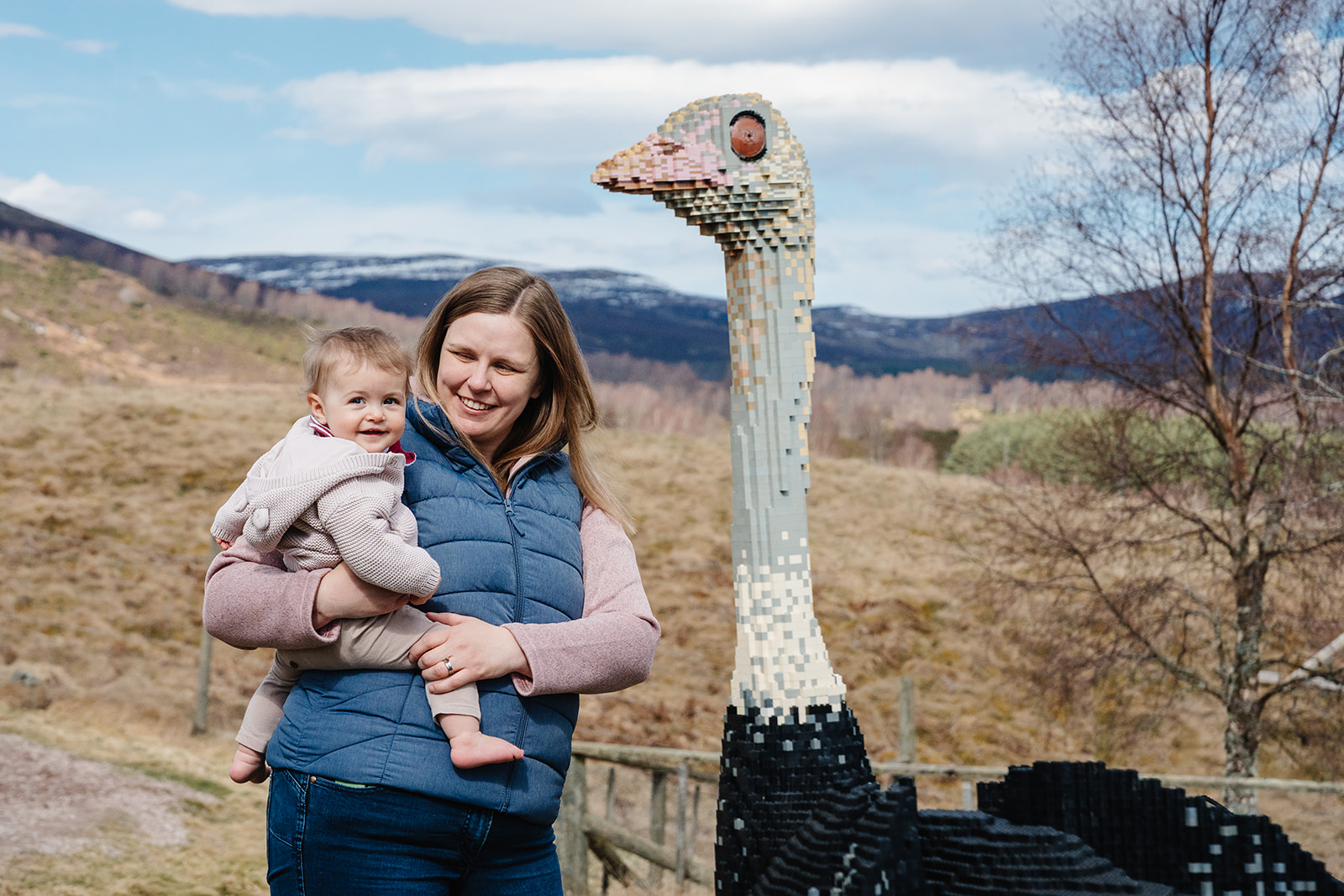 Visitor mum and baby smiling next to ostrich brick sculpture at Highland Wildlife Parks's Bricktastic Beasts trail. IMAGE: Rachel Hein April 2026