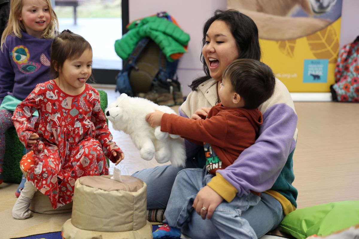 Highland Wildlife Park staff member sitting on the floor with Tadpoles, Froglets and Frogs event attendees. IMAGE: RZSS 2025