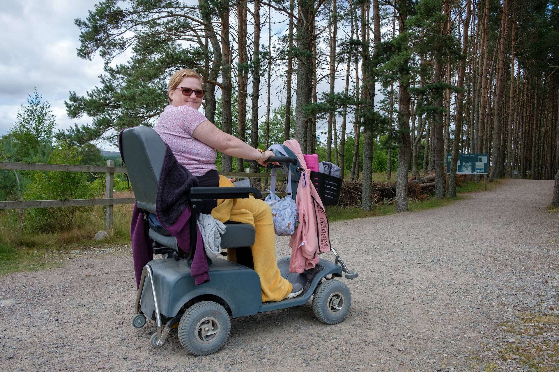 Visitor woman driving rented mobility vehicle to wolf wood IMAGE: Robin Mair 2022
