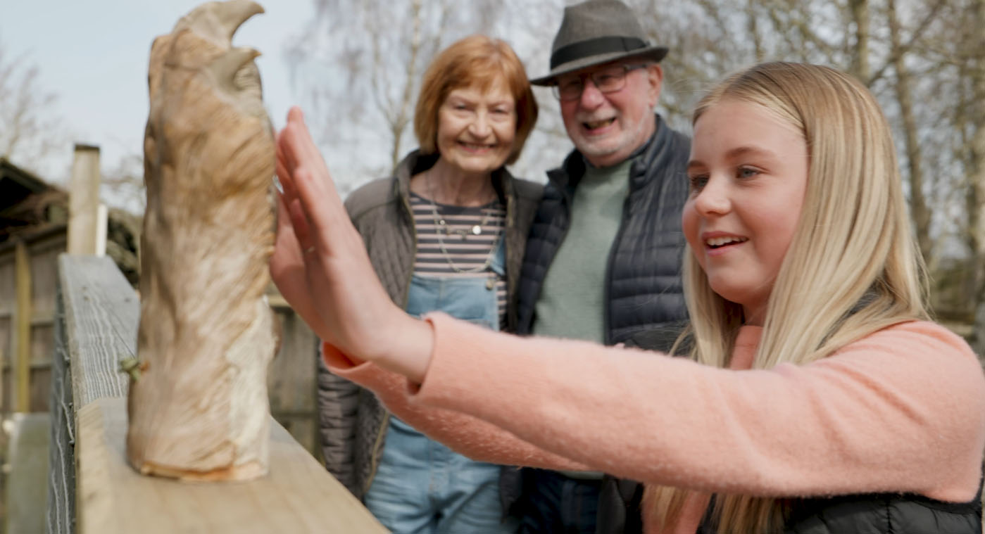 Girl places hand on tiger paw while grandparents look on IMAGE: FoSho 2023