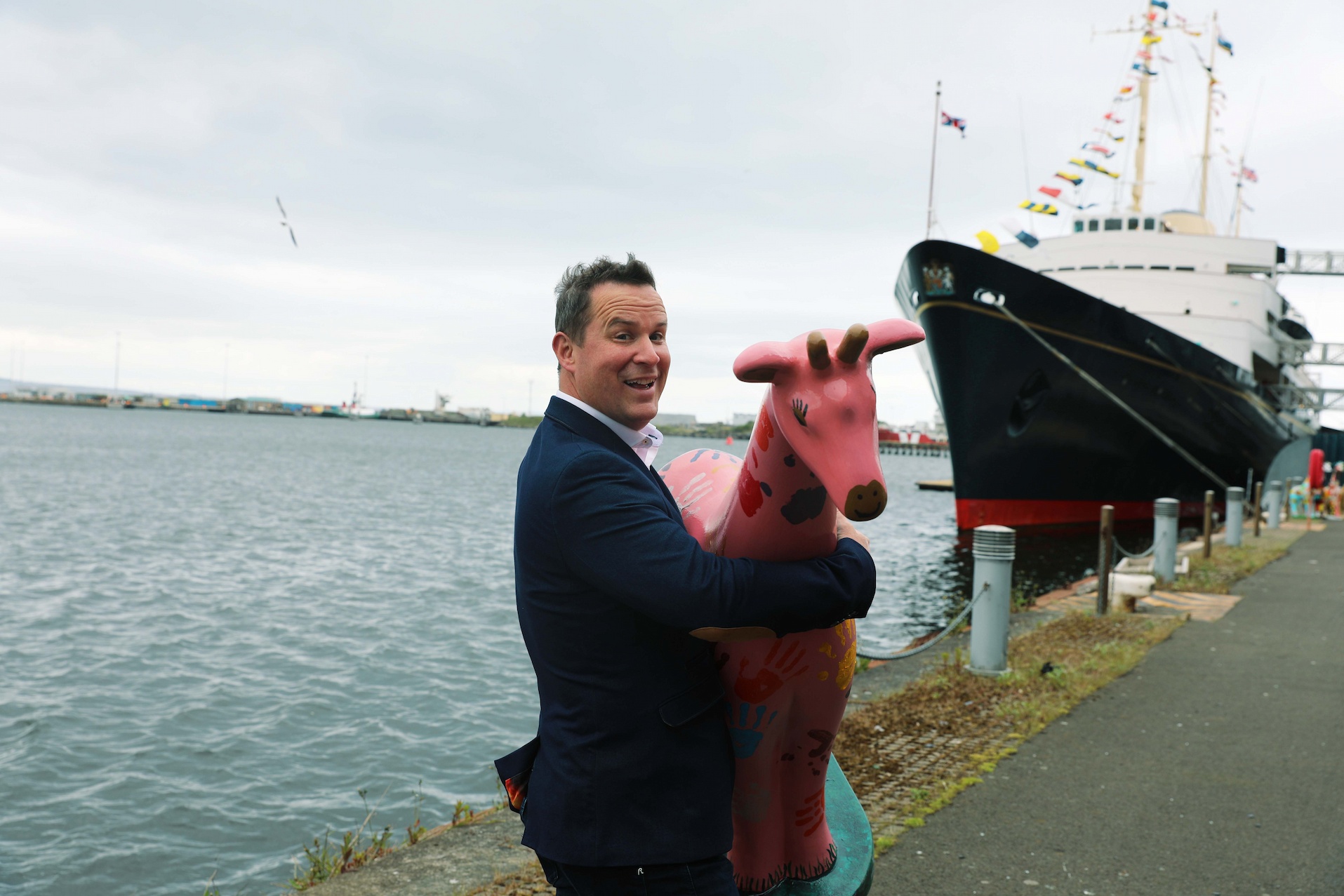 Paul Wakefield City Fibre city manager carrying pink giraffe about town statue near Royal Yacht Britannia

Image: JASMINE GEDDES 2022