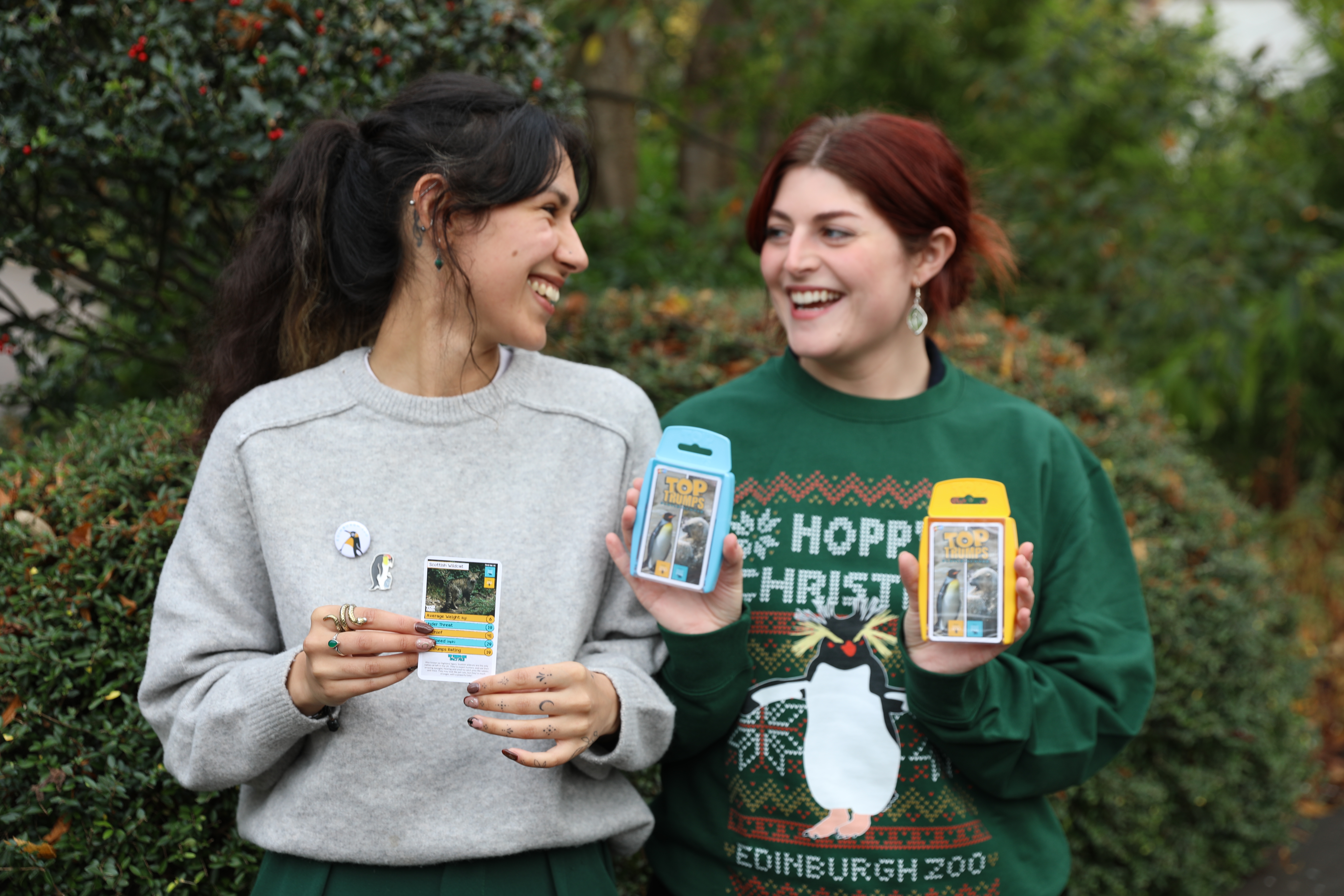 Two girls in Christmas jumpers holding Edinburgh Zoo and Highland Wildlife Park Top Trumps game packs IMAGE: Rhiordan Langan-Fortune 2024